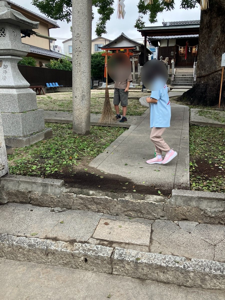 子どもたちが箒やちりとりを持って清掃している様子